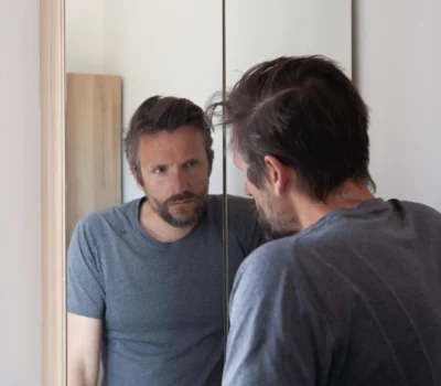 Man looking anxious in bathroom mirror